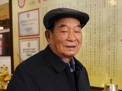 大同铜器非遗传承人李安民和他制作的铜火锅（图片：虞向军）.JPG